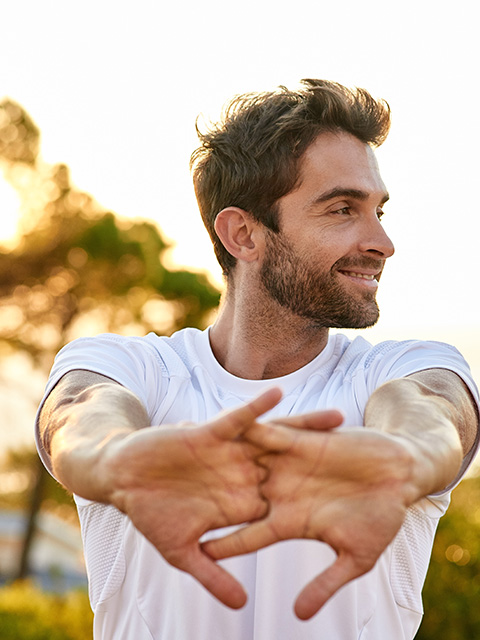 man stretching outdoors enjoying morning sunlight with a focus on fitness and health tips for getting fit at 17